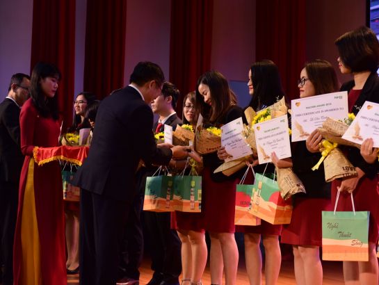 Dr. Dinh Quang Nuong gives flowers, Human books and gold heart badges to teachers of Teacher Award 2018 prize.
